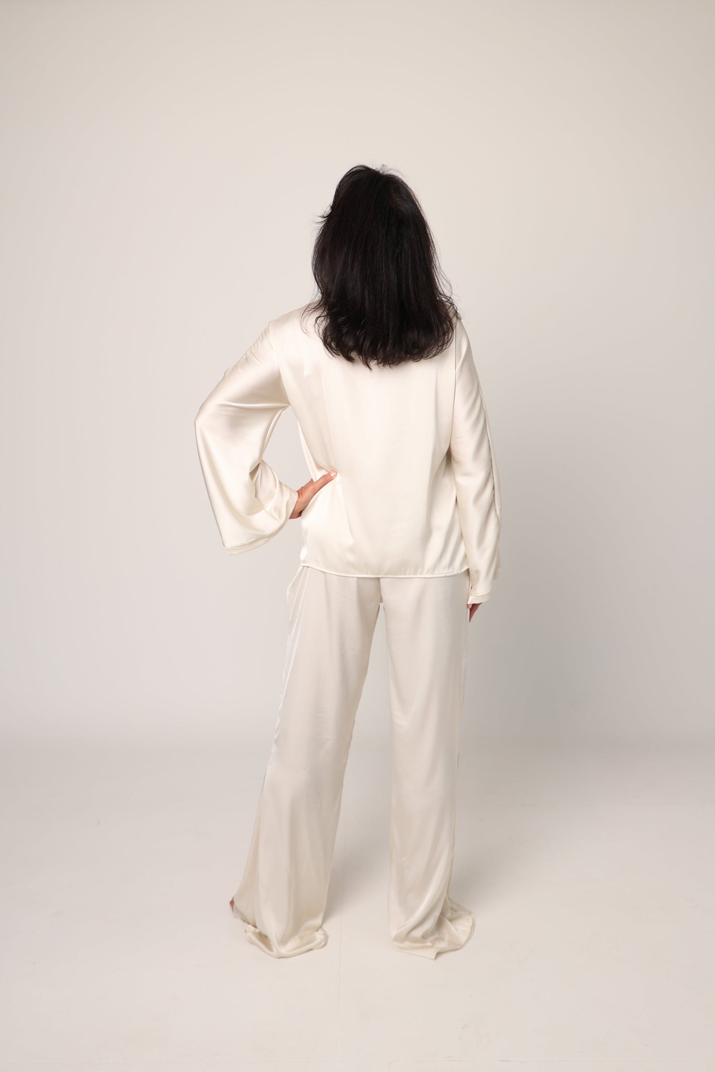 Person wearing a white outfit standing against a plain background