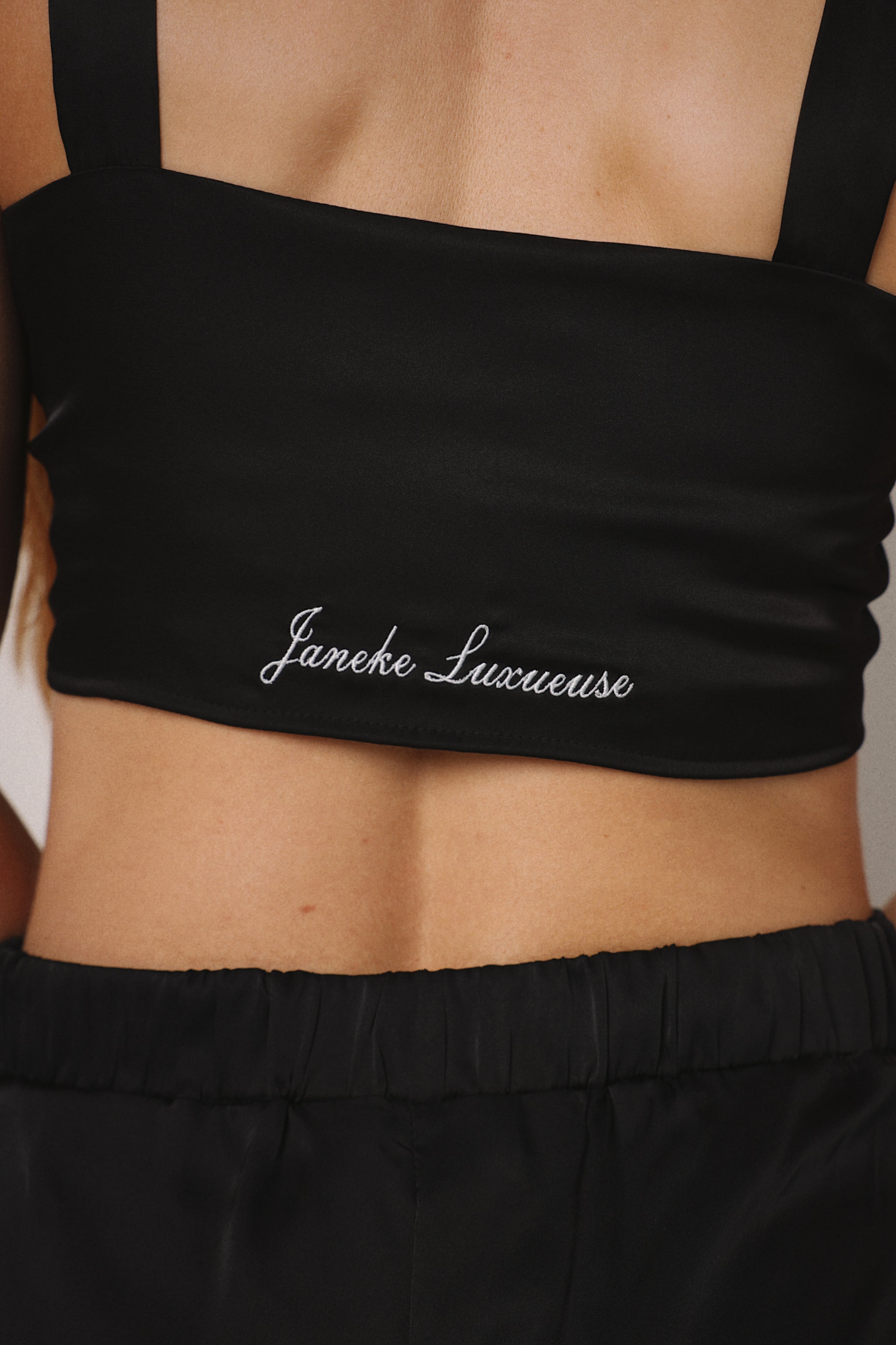 Black garment with 'Jane's Lingerie' branding on a person wearing it.