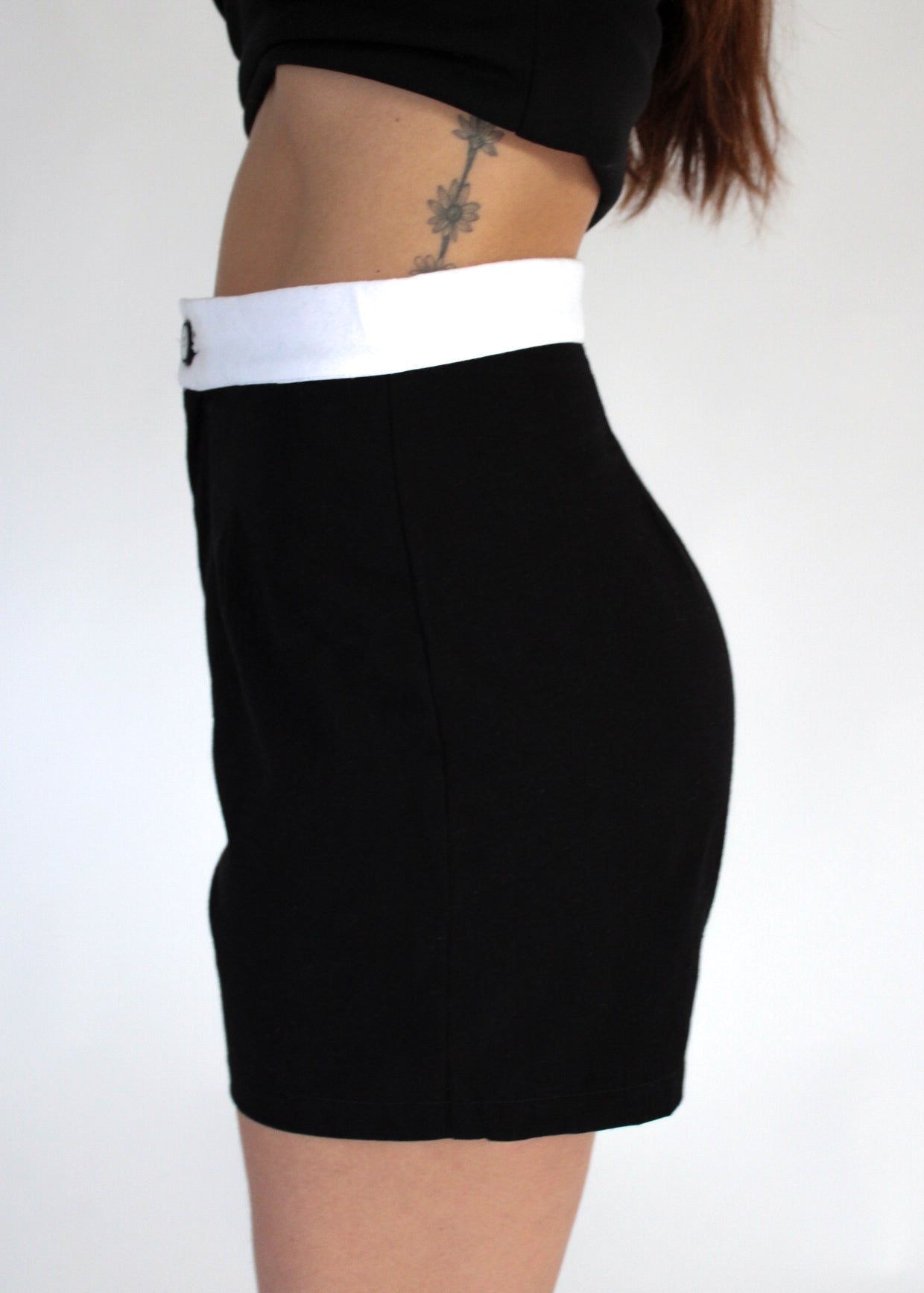 Black skirt with white waistband on a plain background