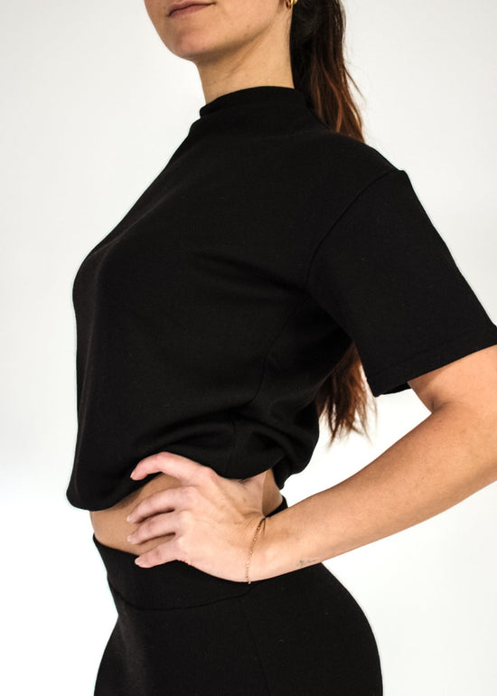 Person wearing a black outfit against a white background