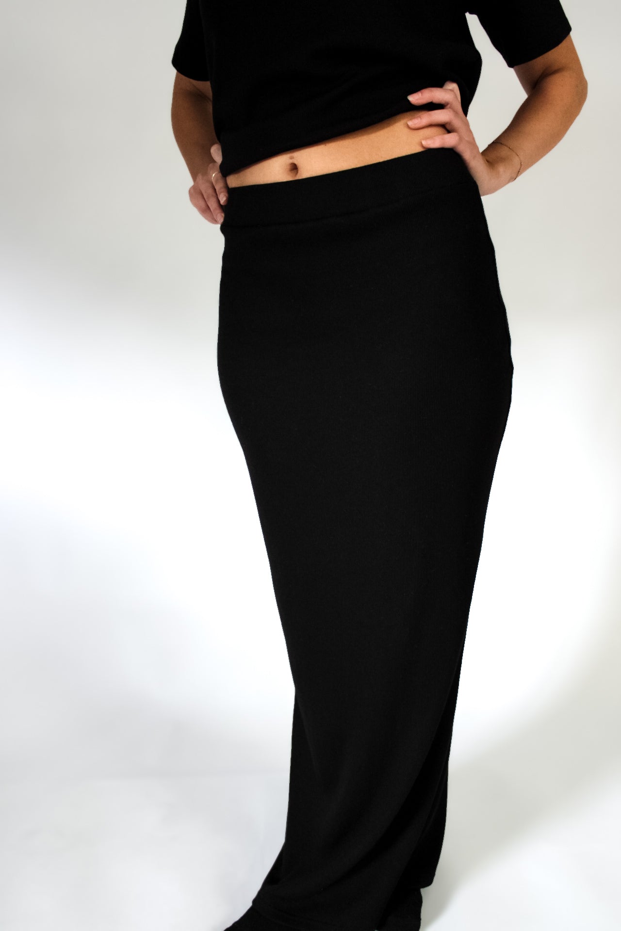 Person wearing a black outfit on a white background