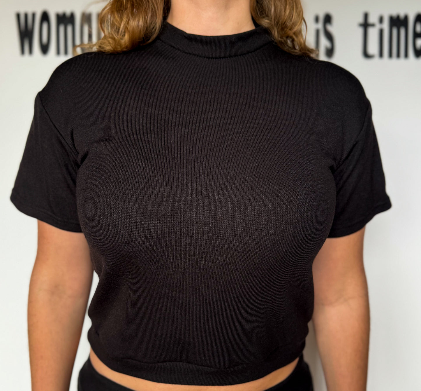 Person wearing a black turtleneck shirt with a white background