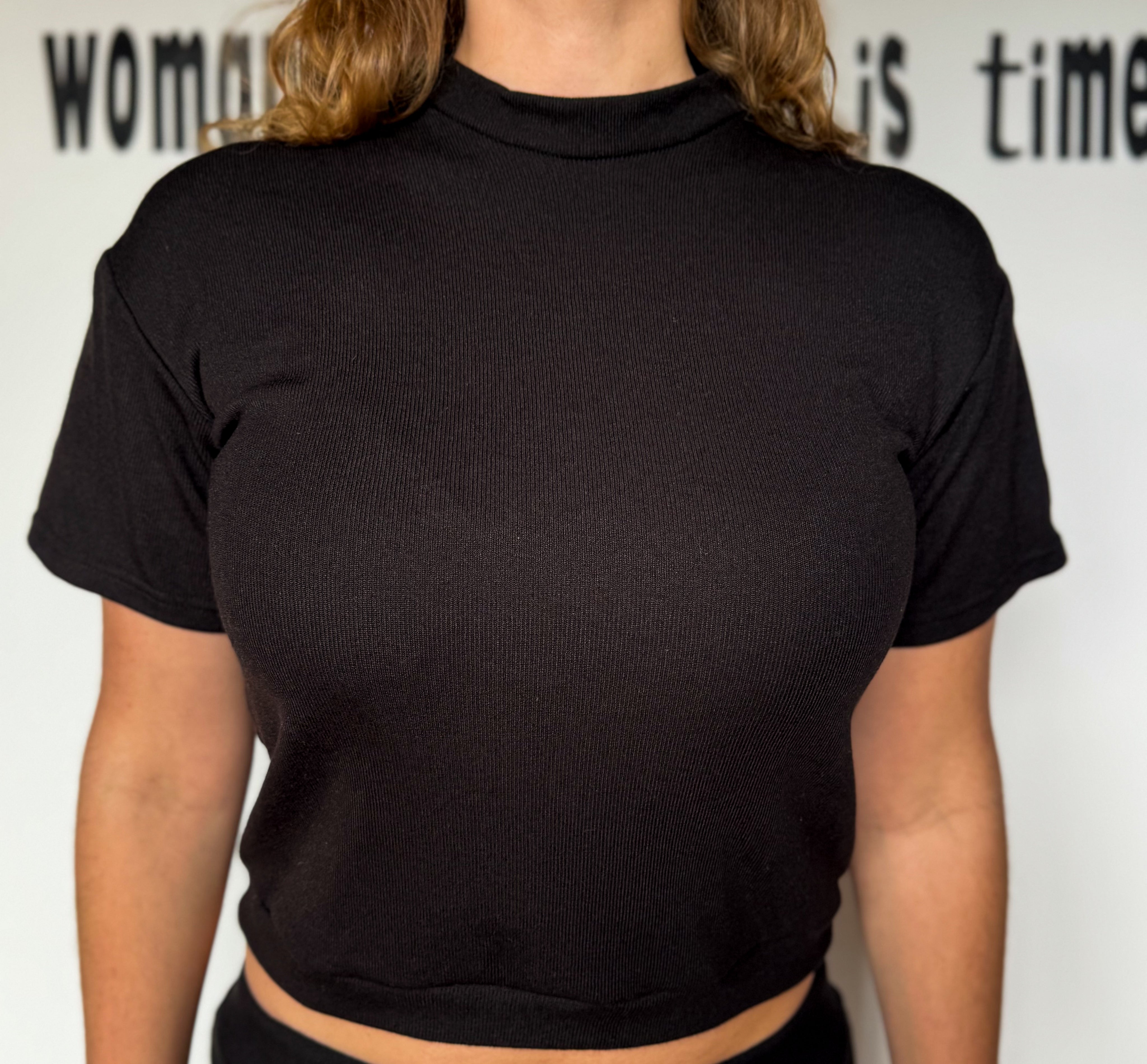 Person wearing a black turtleneck shirt with a white background