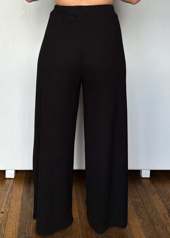 Black wide-leg pants on a plain background