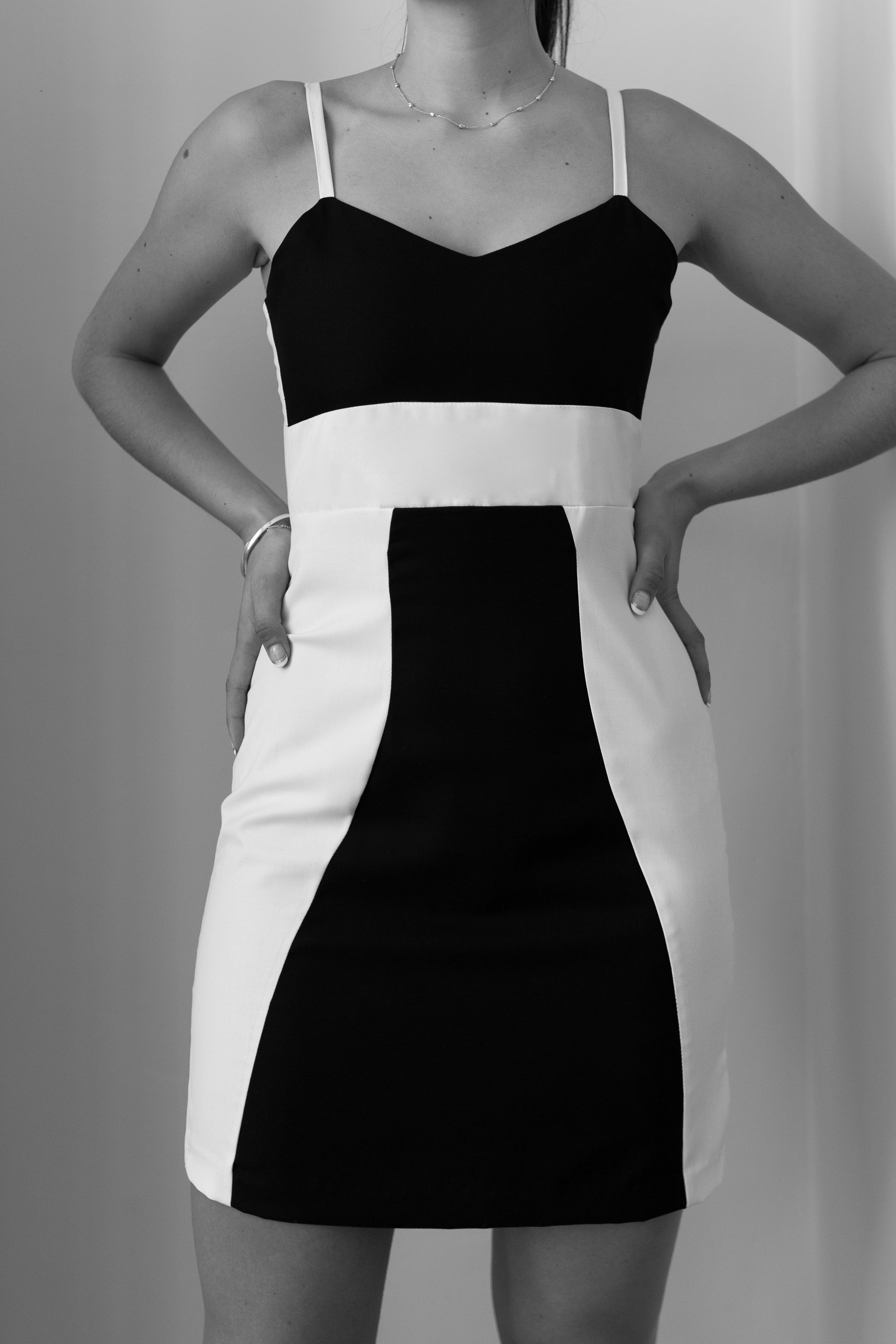 Black and white dress worn by a person on a plain background