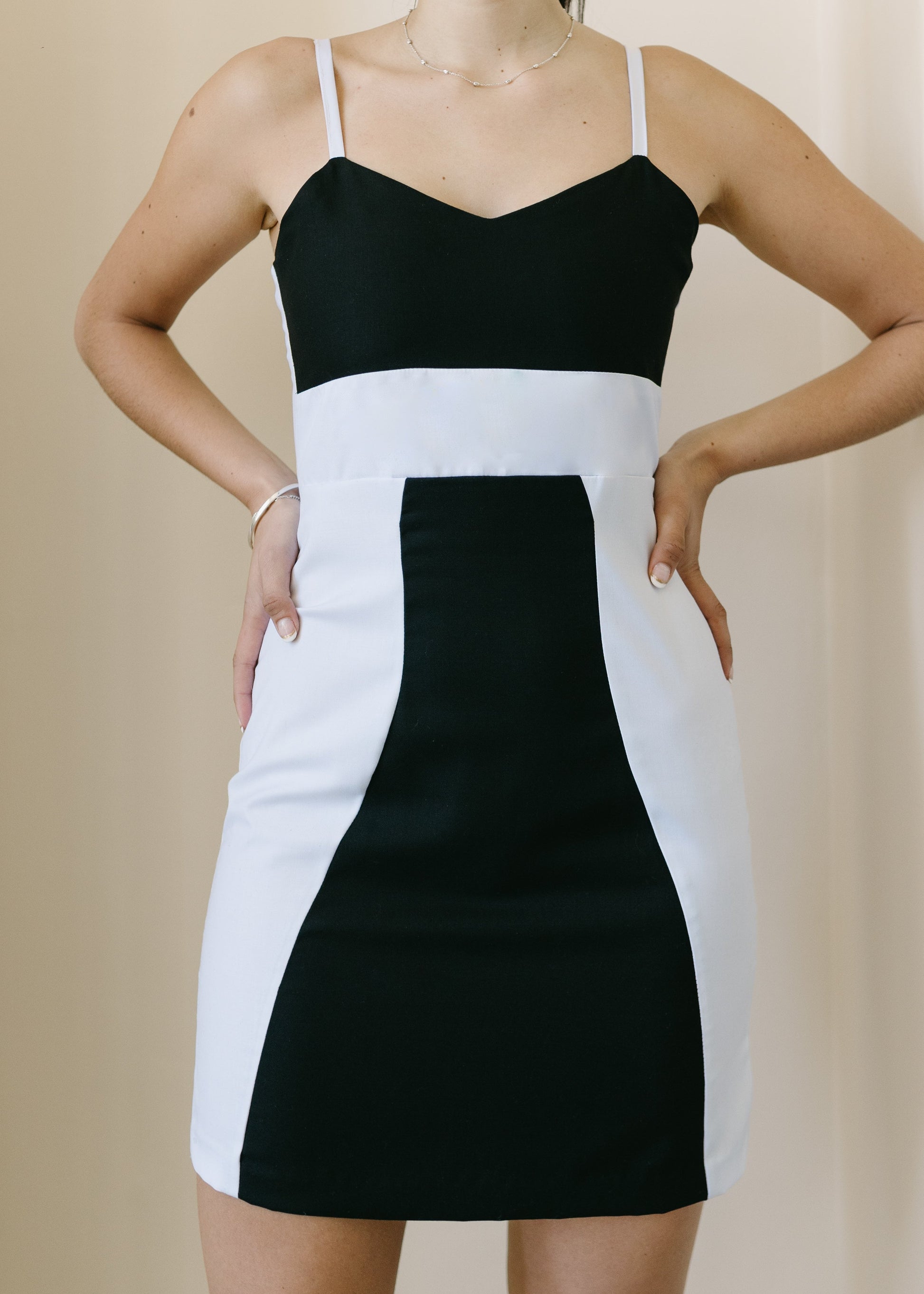 Black and white dress worn by a person on a beige background