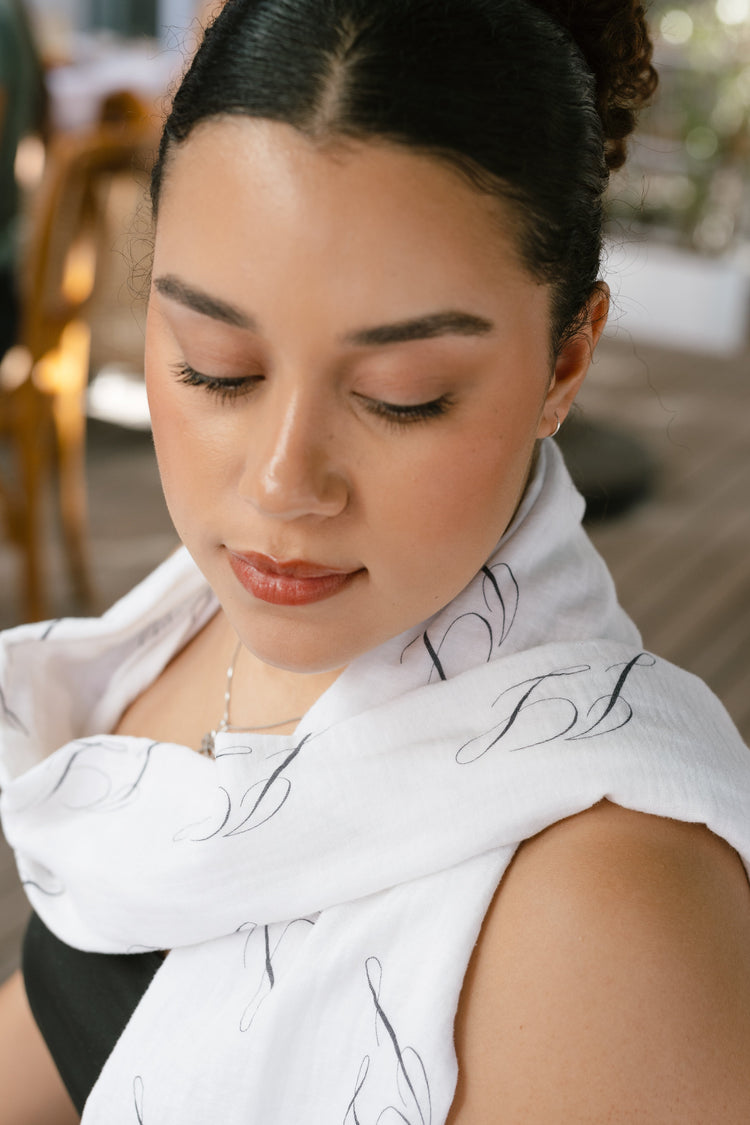 Janeke Luxueuse JL Logo Scarf – white scarf with black JL motifs draped around the neck