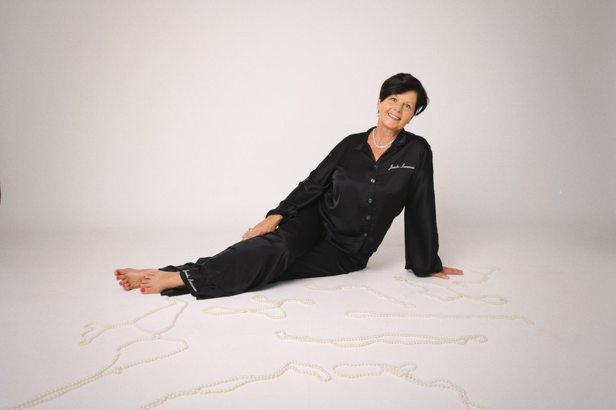 Person wearing black pajamas with 'Jockey' branding on a white background