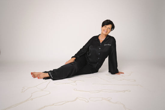 Person wearing black pajamas with 'Jockey' branding on a white background